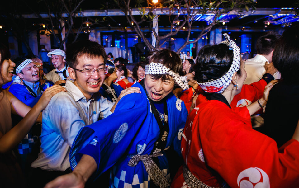 Woman shouting and pointing in conga line at a wedding reception.