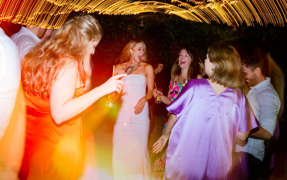 Bride laughs and dances with guests at a wedding reception