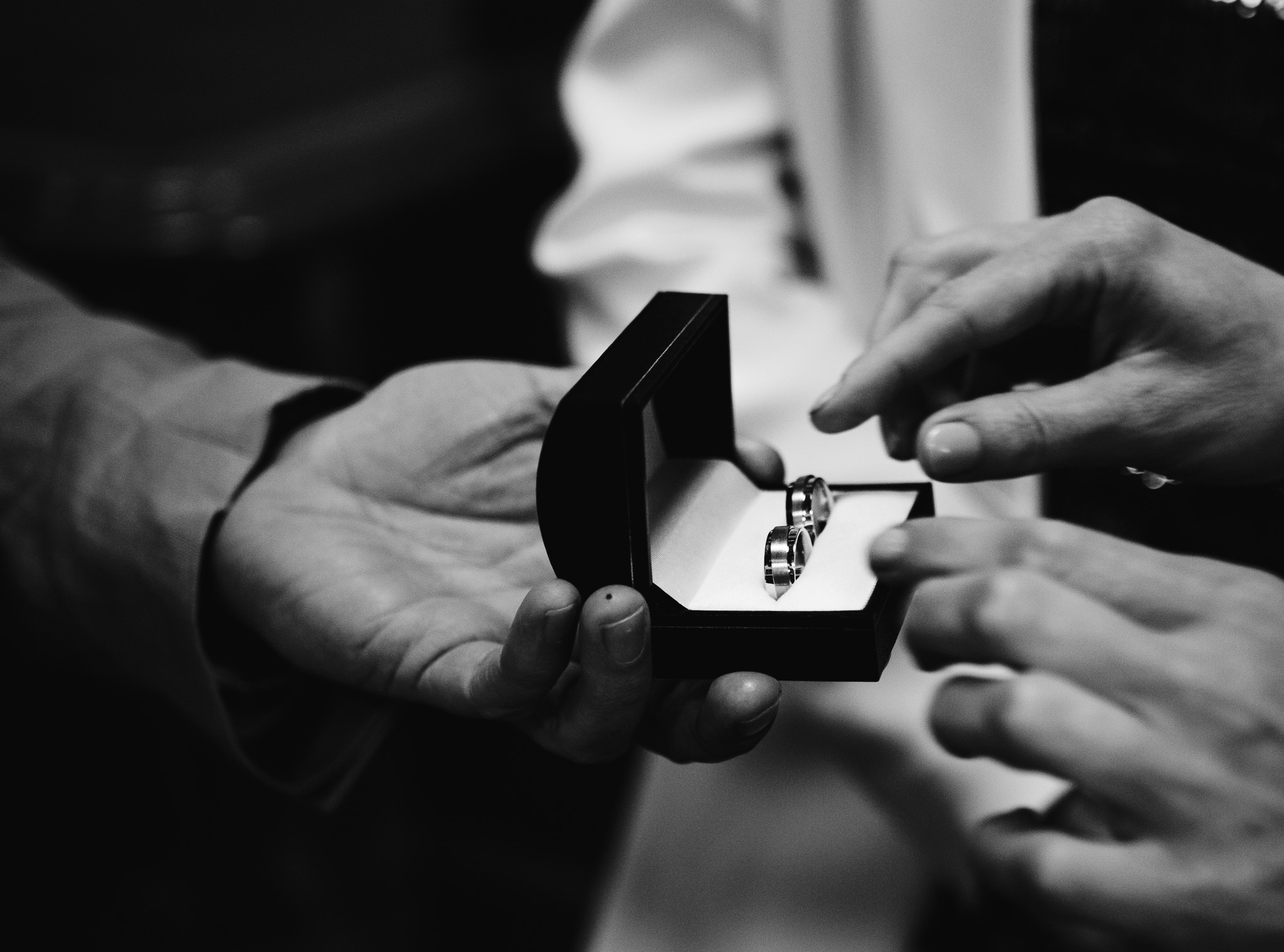 Two wedding rings are presented to the brides in a black box during the wedding ceremony.