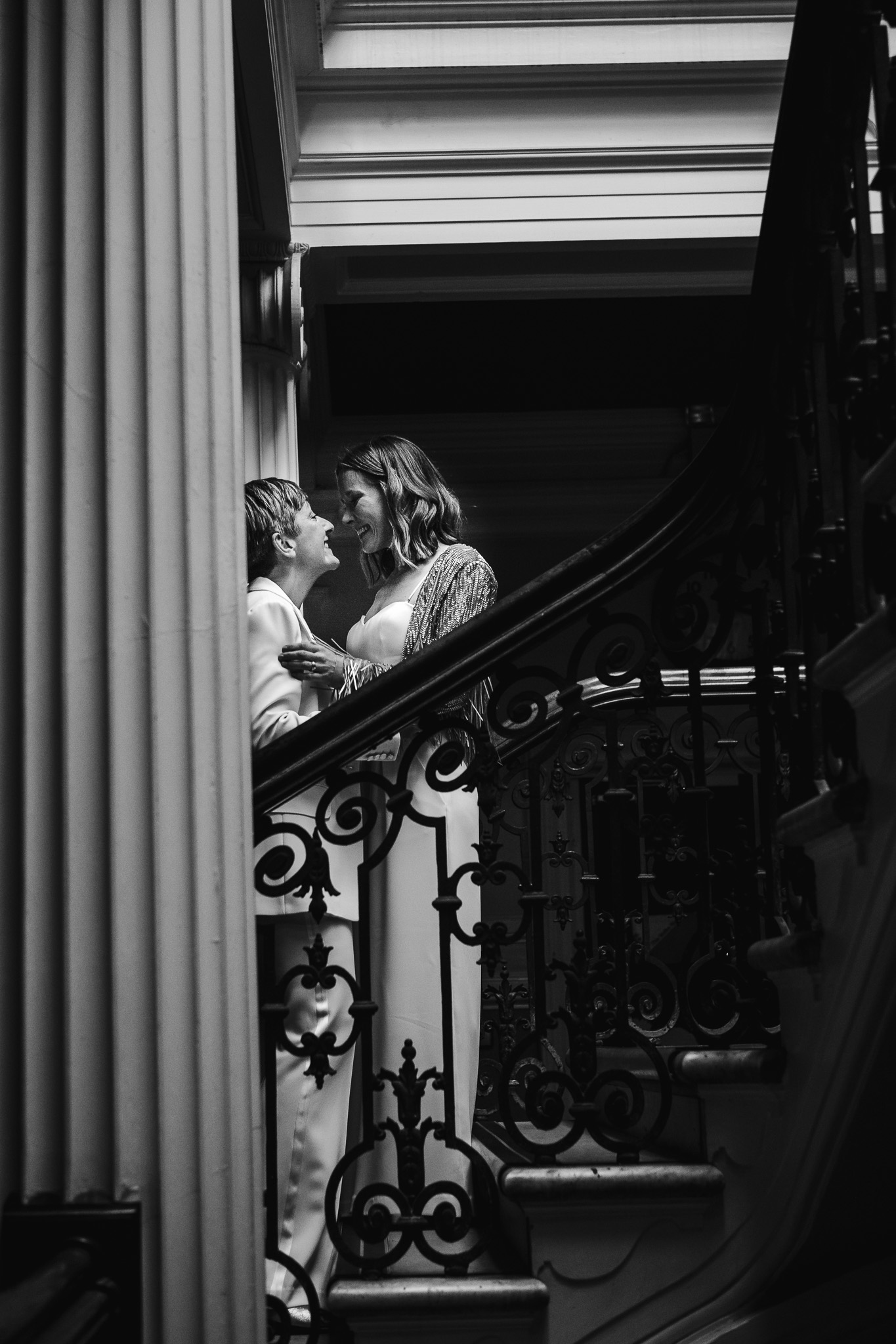 Gemma and Natalie look lovingly at each other on the stairs of Brighton Town Hall after their wedding ceremony.