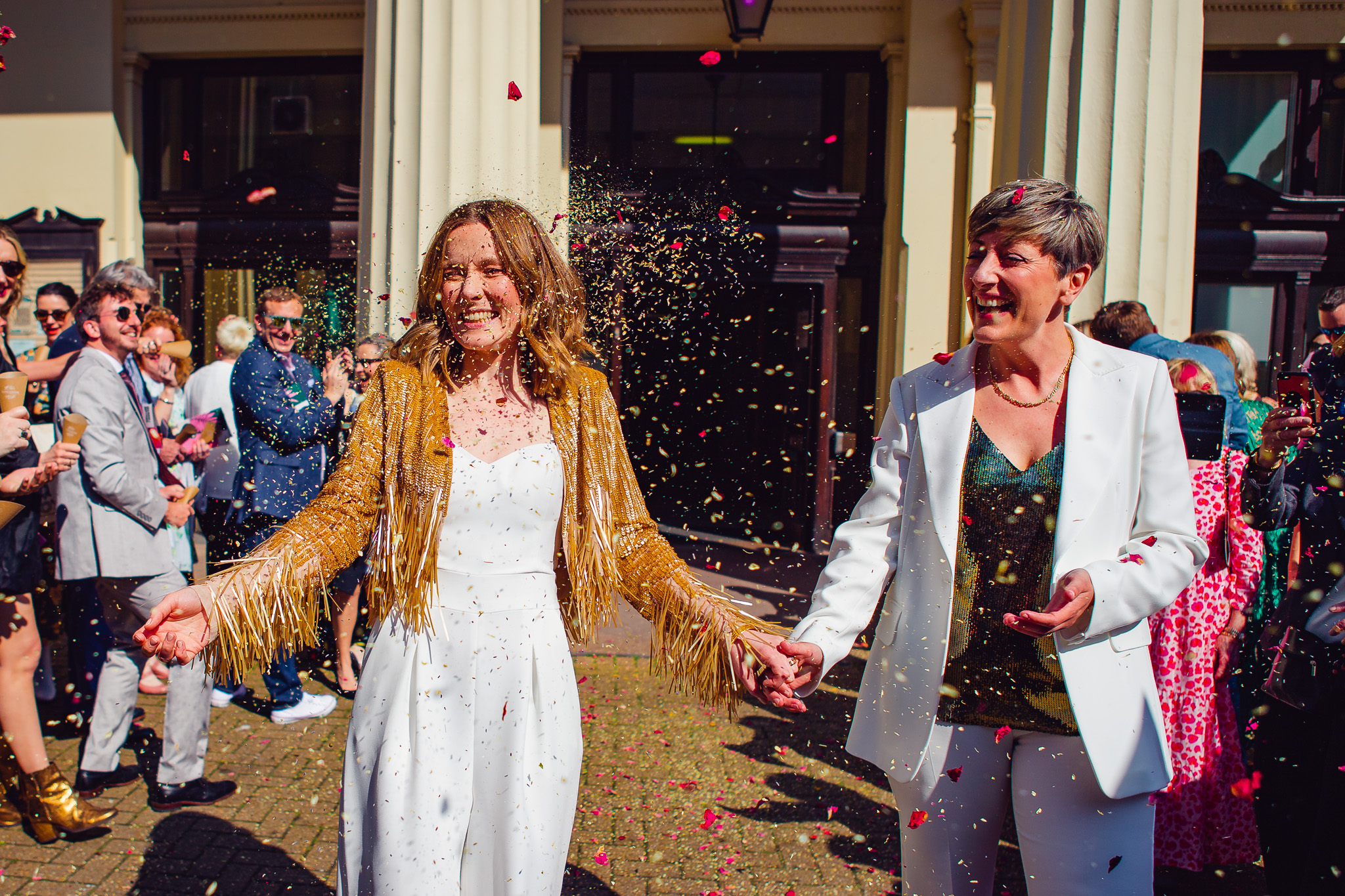 Colourful confetti is thrown at the two newlywed brides outside Brighton Town Hall.