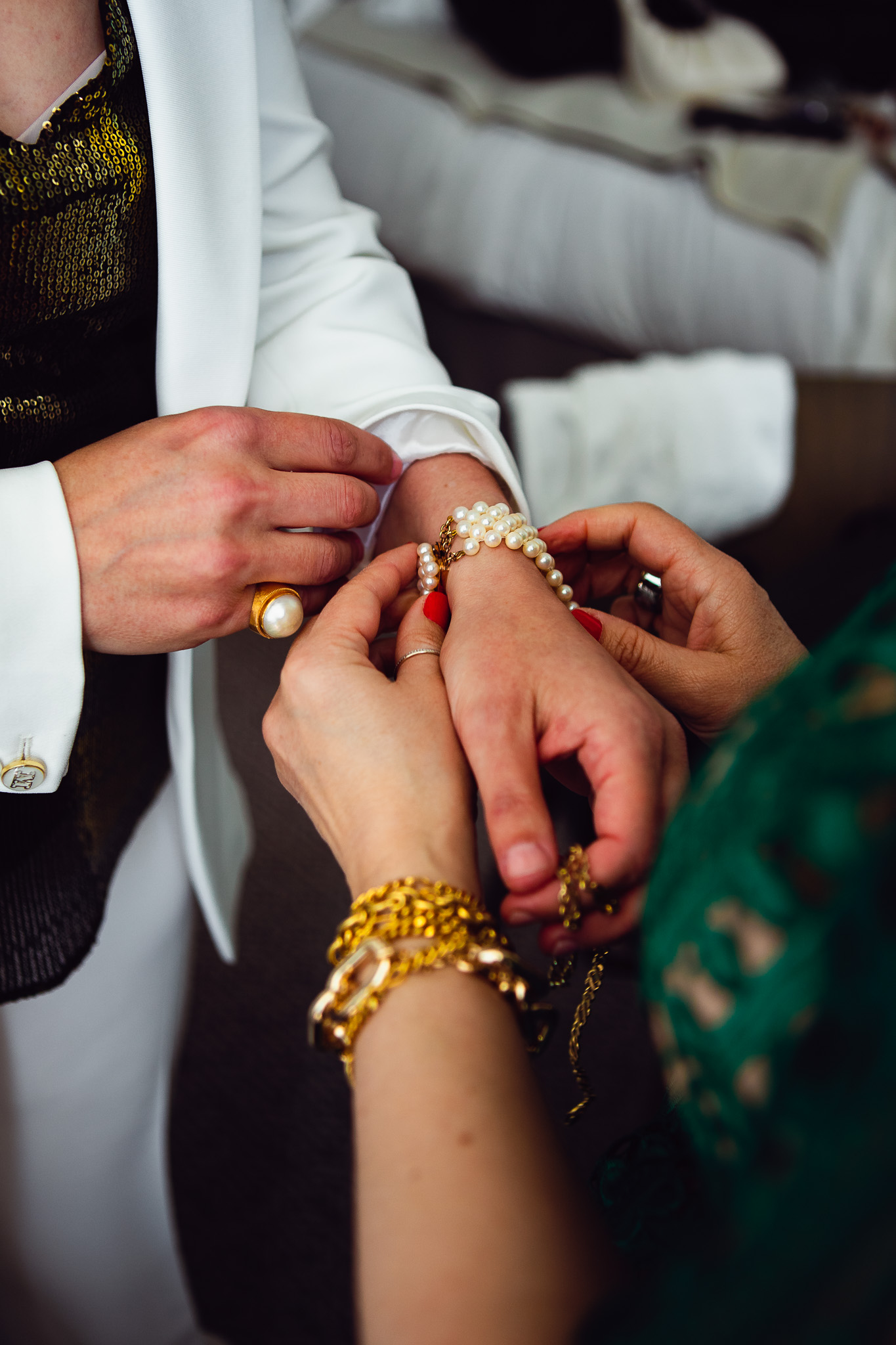 Natalie gets help putting on her pearl bracelet in preparation for her wedding day.