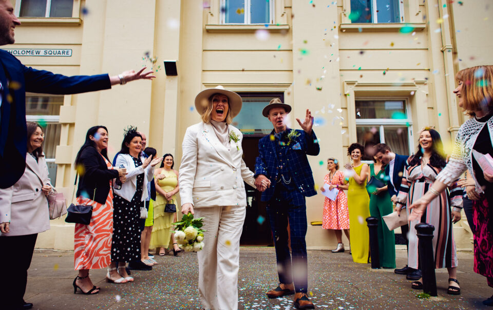 Mary shouts and Mike smiles as they have confetti thrown at them outside Brighton Town Hall.